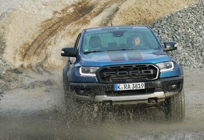 Ford Ranger fährt dynamisch durch Matsch in einer Kiesgrube