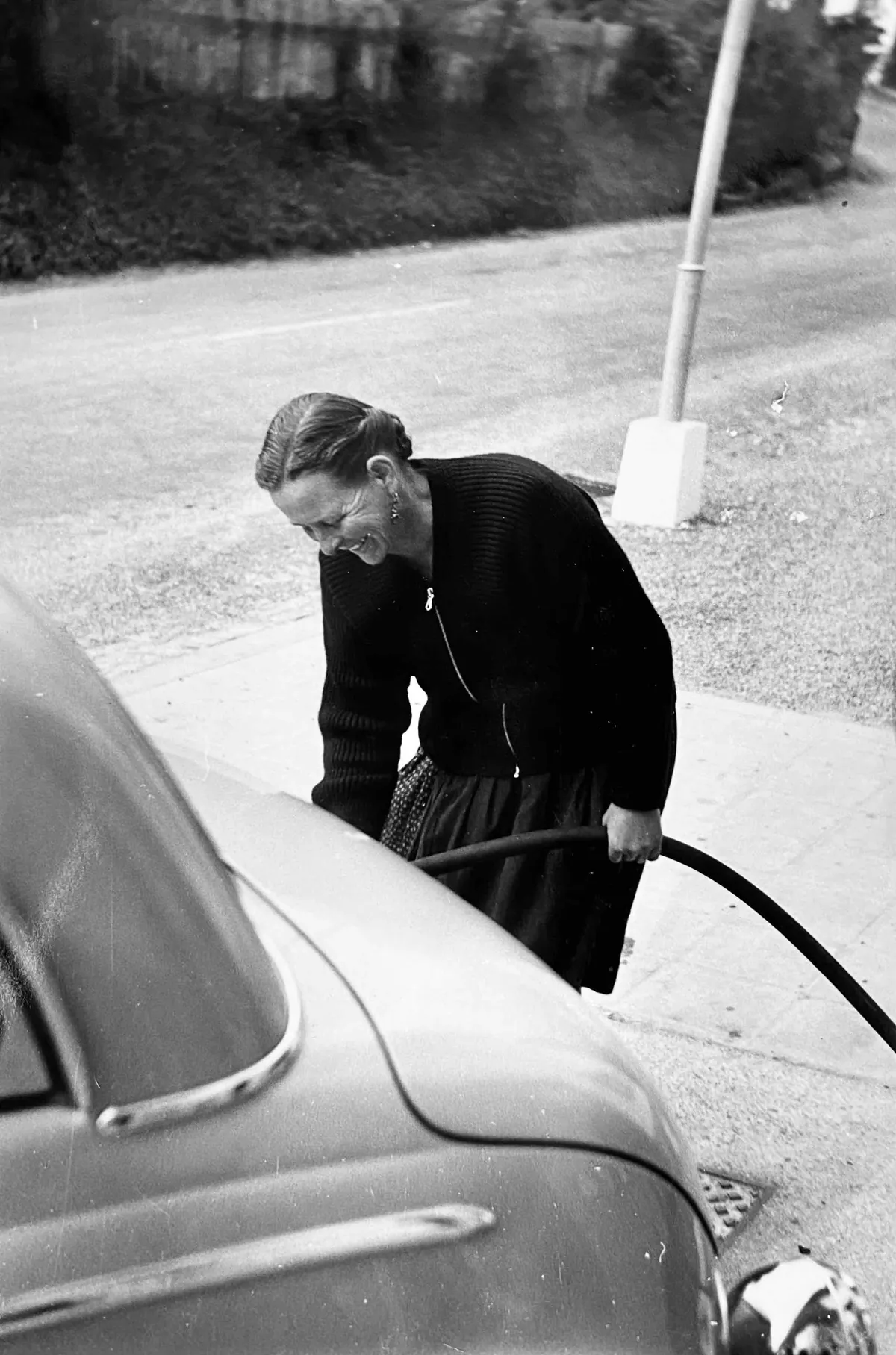 Dora Müller betankt in den 1950er Jahren ein Auto an ihrer Shell-Tankstelle in Hindelang