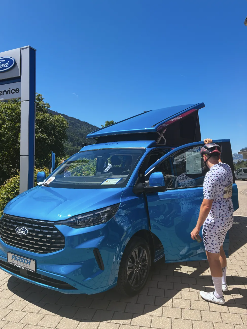 Radfahrer betrachtet den Ford Transit Custom Nugget Campervan beim Pit Stop des Autohaus Fersch