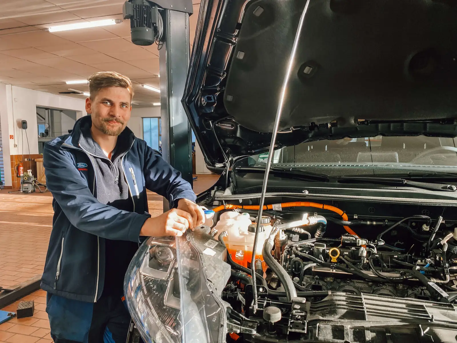 Motordiagnose in der Kfz-Werkstatt Bad Hindelang: Mechaniker am geöffneten Motorraum